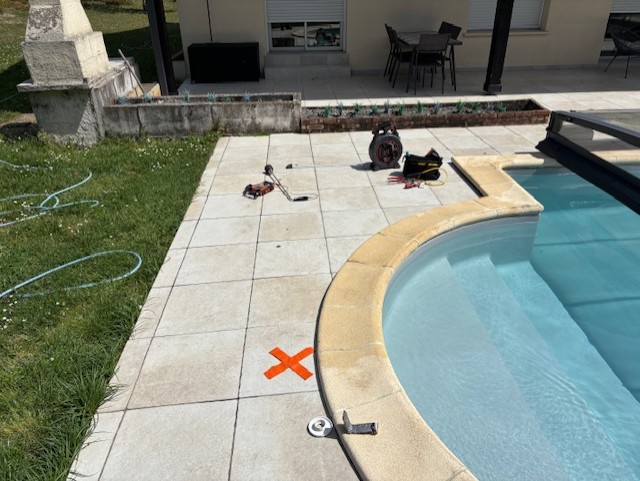 Croix orange au sol marquant l'endroit exacte de la fuite sur une canalisation enterrée de refoulement de la piscine à Cestas