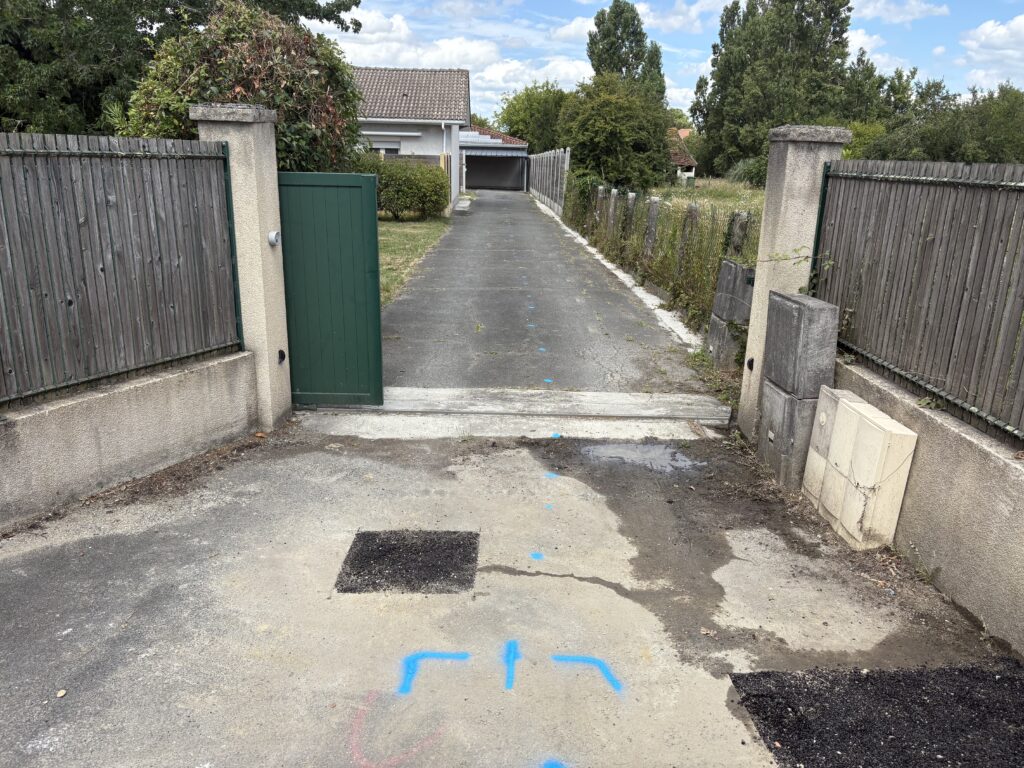 Photo de l'allée goudronnée du client à Eysines avec le tracé du réseau et la localisation précise de la fuite enterrée.